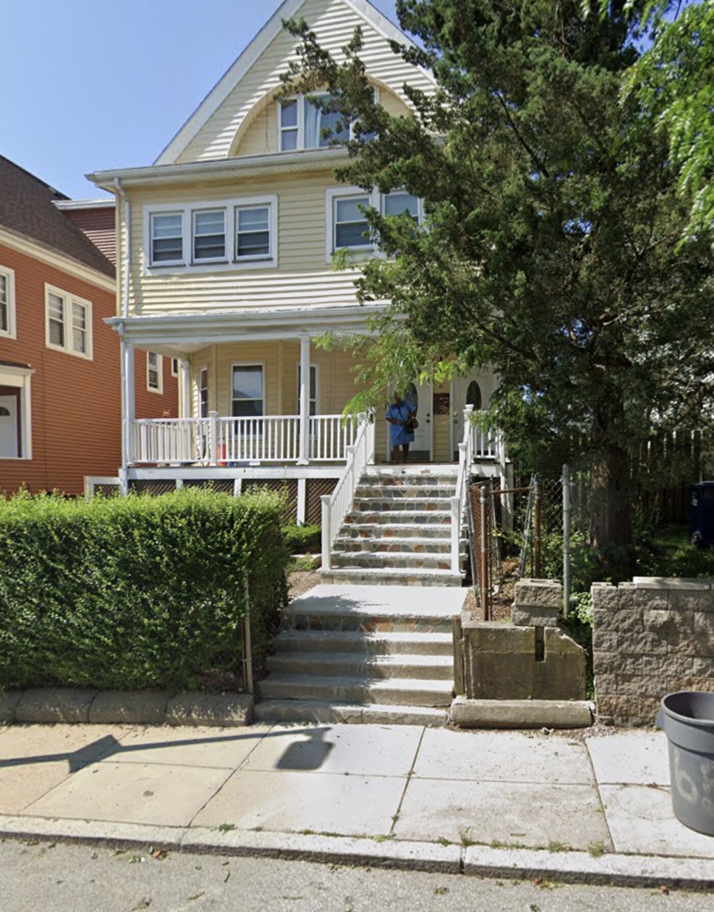 Front exterior of the Blue Hill Residences home, with a covered porch and stone steps